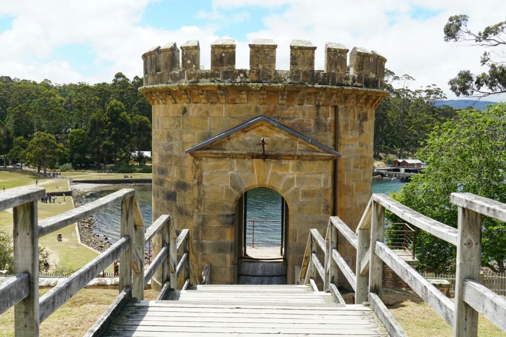 a wooden bridge leading to a stone tower